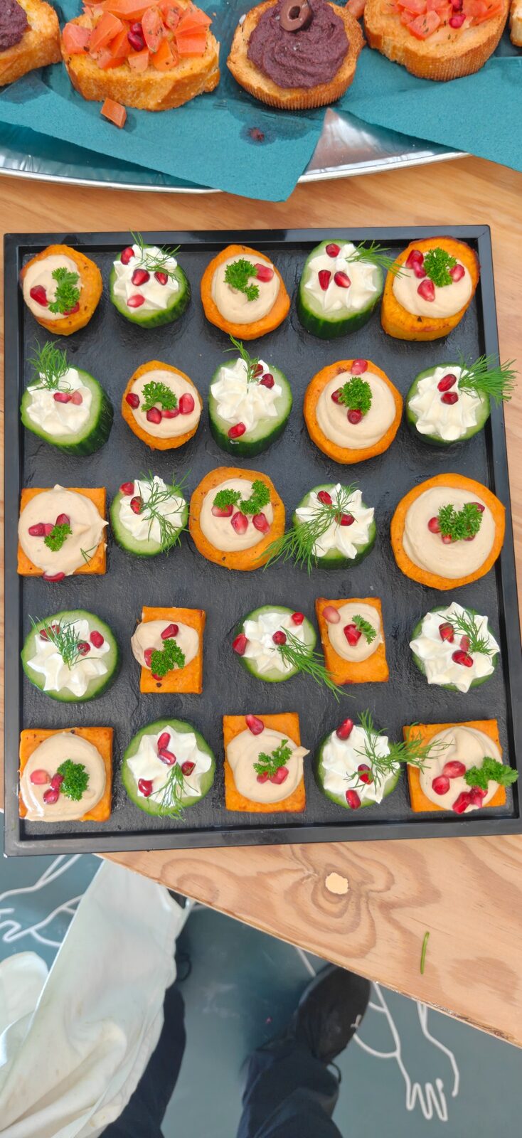 Canapés auf Schieferplatte mit Frischkäse, Dill und Granatapfel